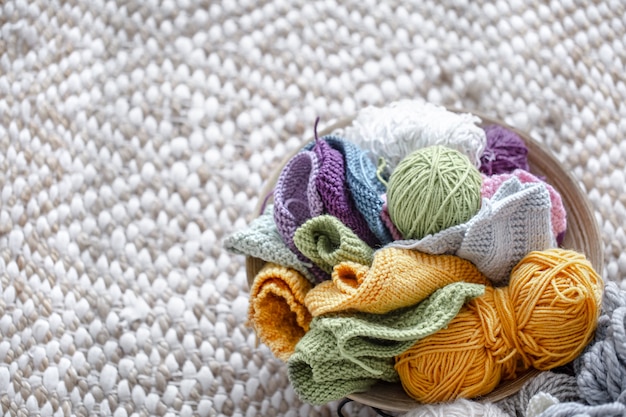 Multicolored balls of thread for knitting in the basket copy space.