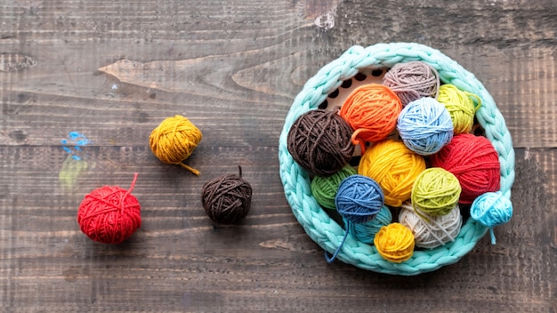 Photo multicolored balls of yarn in and near the knitted couch