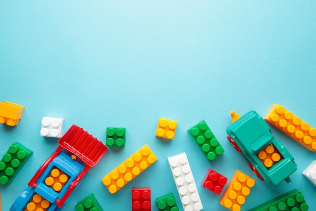 Multicolored blocks of the children's constructor lie on blue background Top view