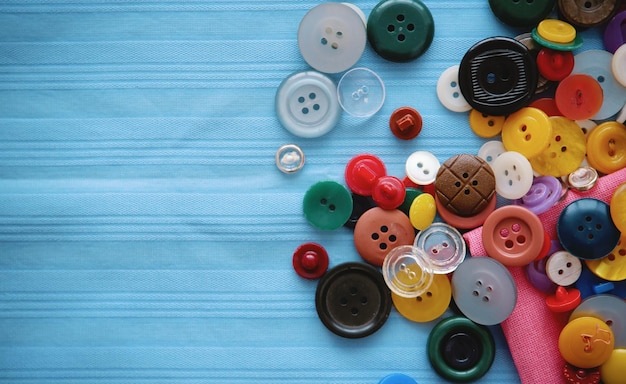 Photo multicolored buttons on blue fabric place for an inscription