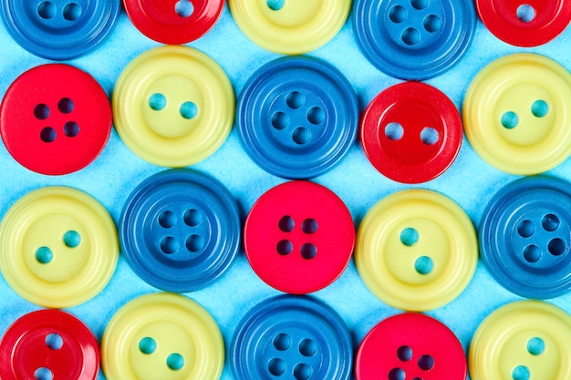 Multicolored buttons for clothess on a blue background