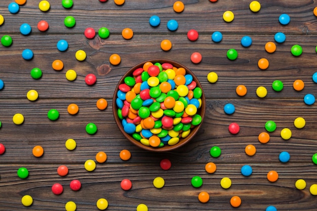 Разноцветные конфеты в миске на цветном фоне концепции дня рождения и праздника Вид сверху с копией пространства