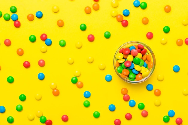 Photo multicolored candies in a bowl on a colored background birthday and holiday concept top view with copy space