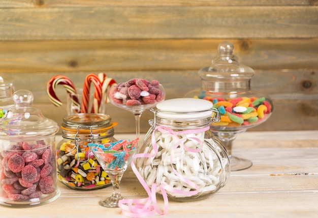 Photo multicolored candies in glass candy jars.