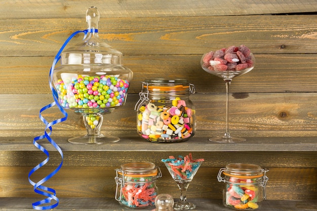 Photo multicolored candies in glass candy jars.