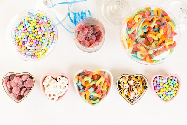 Разноцветные конфеты на белом столе.