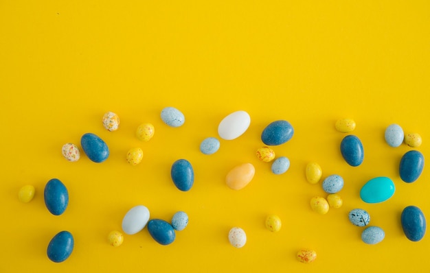 multicolored candies on a yellow background with space for text