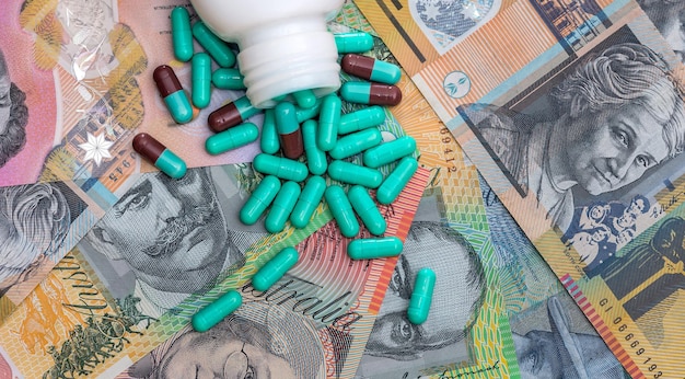 Multicolored capsules and pills antibiotics on Australian banknotes in piles AUD Medical concept