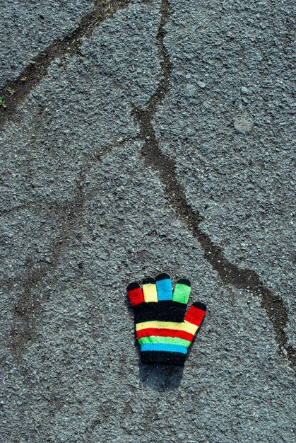 Photo multicolored children's glove on the pavement