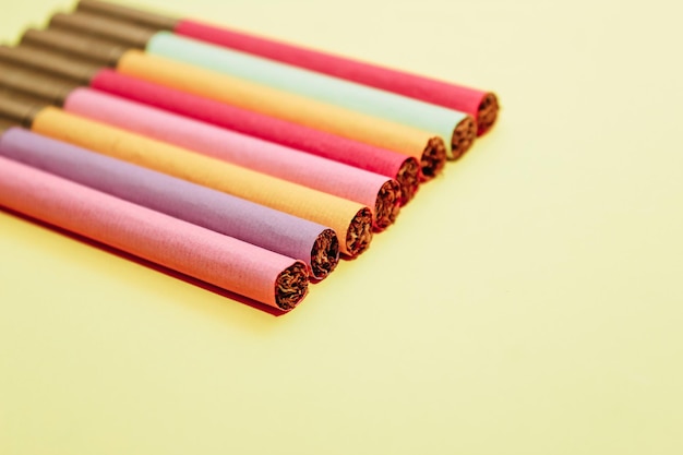 Multicolored cigarettes on a paper background the concept of a bad habit