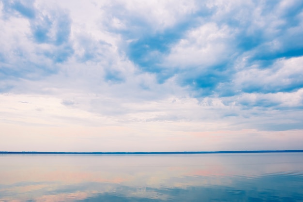 Multicolored clouds in the blue sky over the sea.