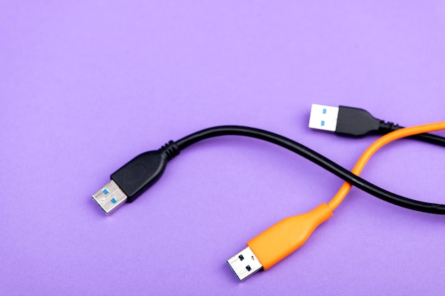 Разноцветный компьютерный кабель USB изолирован на фиолетовом фоне