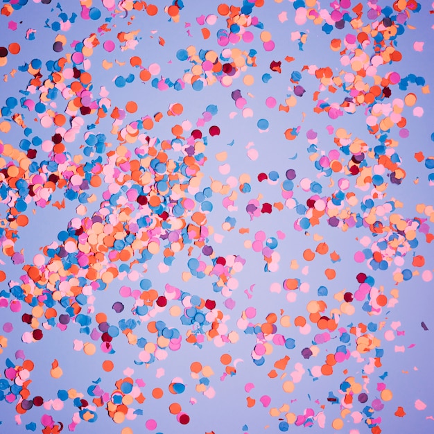 Photo multicolored confetti over blue backdrop