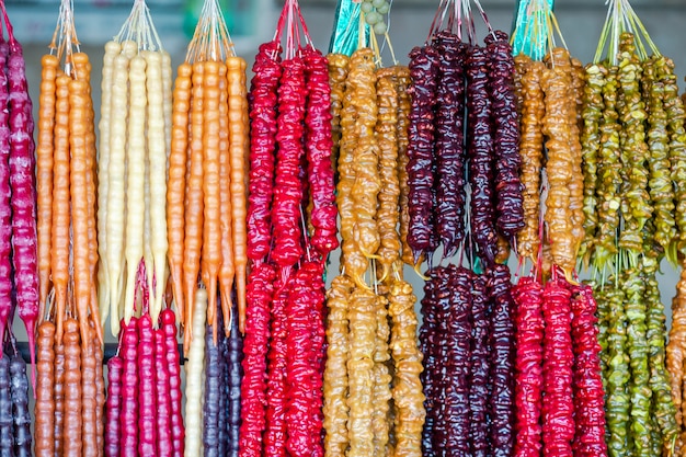 Multicolored delicious fresh Georgian Sweets Churchkhela hanging in the market