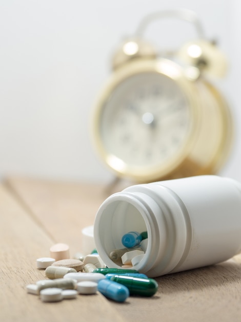 Multicolored of Drug and capsule is on the wooden table