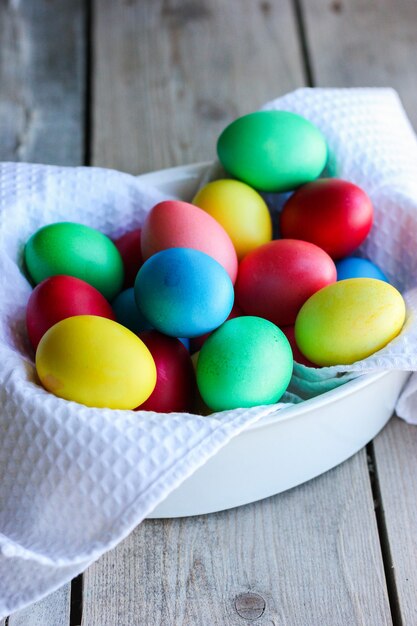 Uova di pasqua multicolori in una ciotola bianca