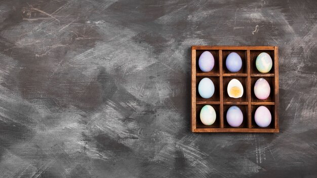 Multicolored eggs for Easter on black background. Top view, copy space. Food background