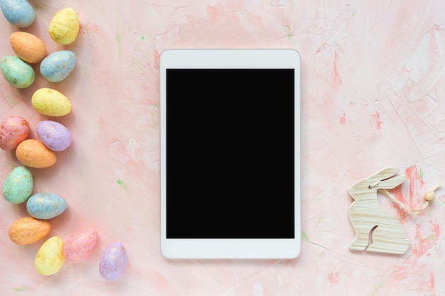 Photo multicolored eggs and tablet on pink background easter mockup internet advertising shopping