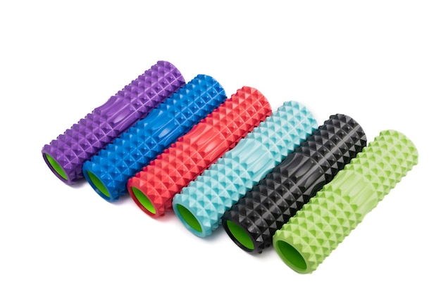 Photo multicolored foam rollers isolate on white background. gym fitness equipment. self body care massage and pain relief.