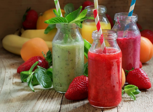 Multicolored fruit and berry smoothies old wooden table selective focus