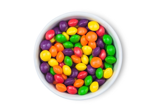 Multicolored fruit candies in plate on white background Top view