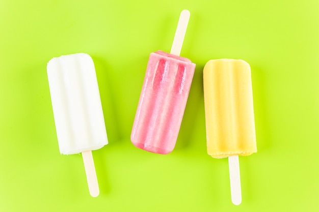 Multicolored fruit ice cream bars on colored background.