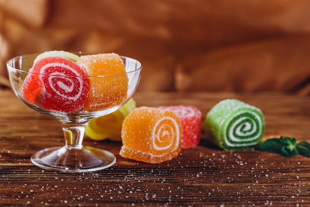 Photo multicolored fruit marmalade lies on a wooden table