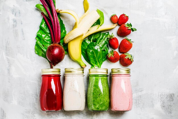 Multicolored juices and smoothies of fresh vegetables fruits and berries top view food background