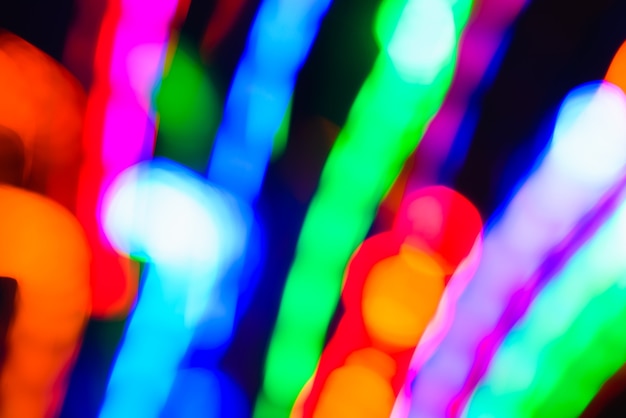 Multicolored lights in motion blur, abstract festive color design, futuristic bokeh backdrop on dark background