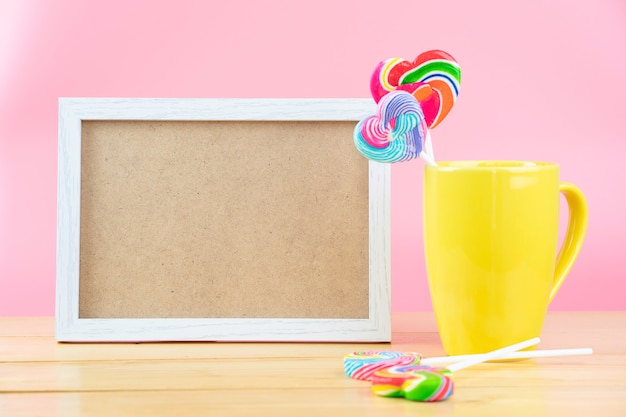 Foto lecca-lecca multicolori in un contenitore su un fondo rosa con lo spazio della copia