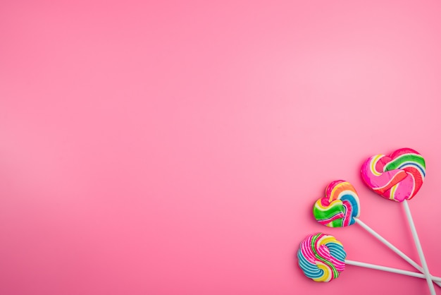 Multicolored lollipops on a pink background