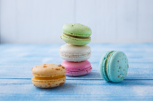 Multicolored macaroons on blue background. Copy space