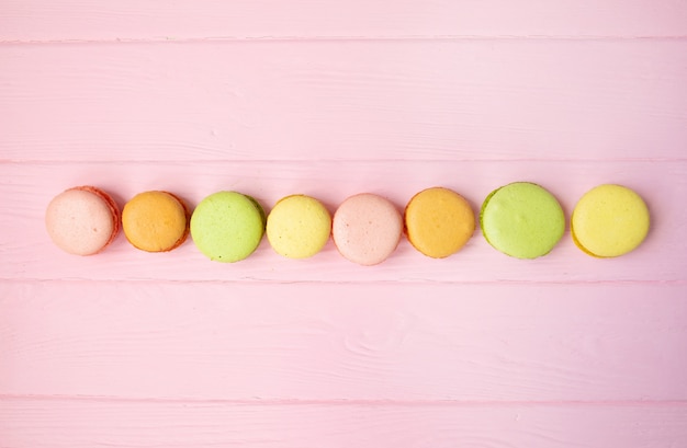 Multicolored macaroons on pink background.