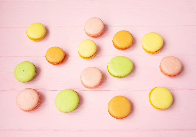 Multicolored macaroons on pink table