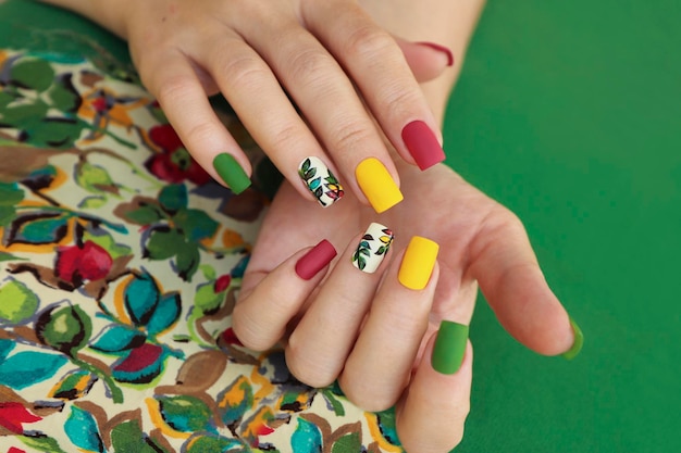 Multicolored manicure on square nails with floral design.