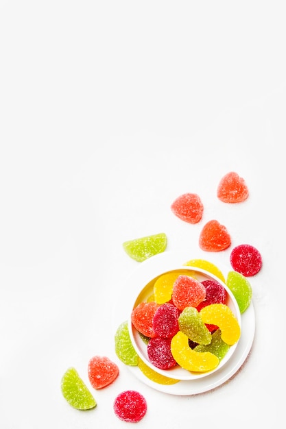 Multicolored marmalade in sugar light background top view