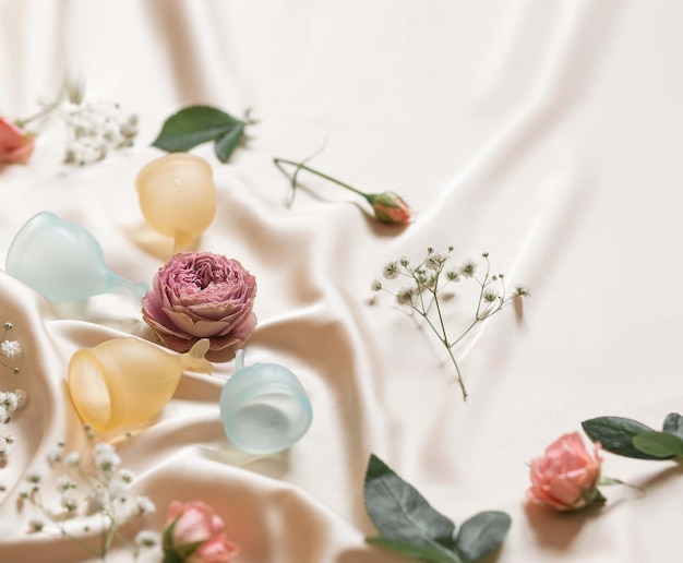 Multicolored menstrual cups on a silk background