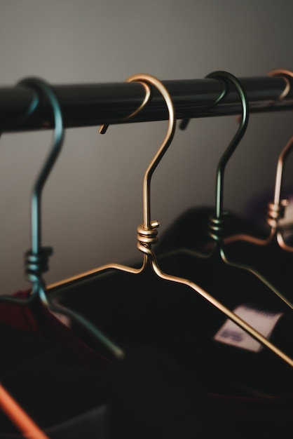 Multicolored metal clothes hangers in wardrobe 