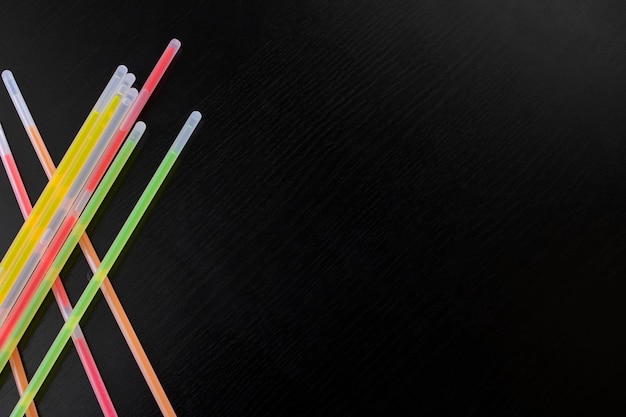 Multicolored neon sticks on a wooden background