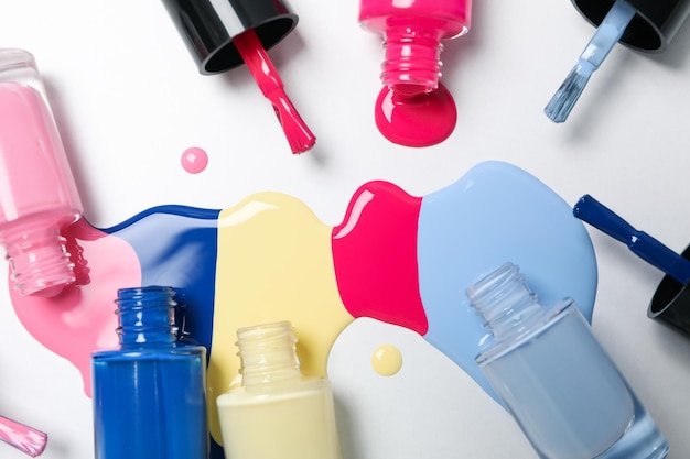 Multicolored open nail polishes on a white background