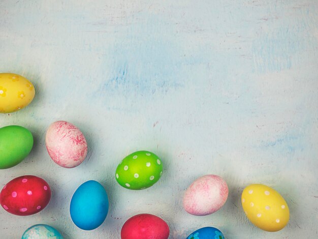 Multicolored painted eggs on a blue background The concept of Easter Place for text