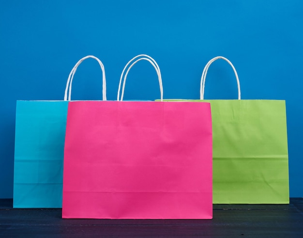 Multicolored paper bags with a handle for shopping and gifts on a blue background