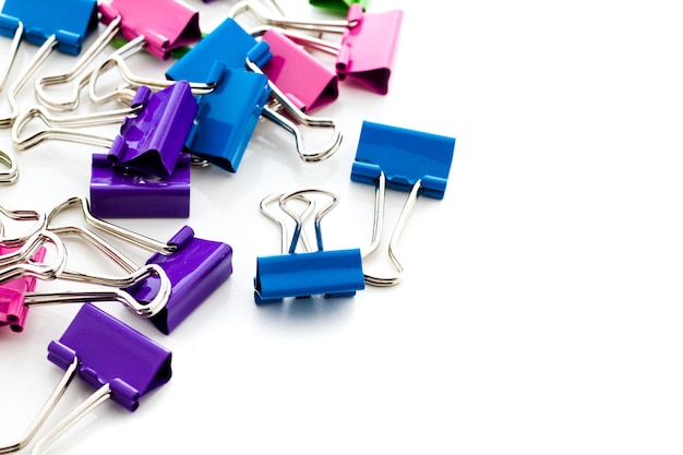 Multicolored paper clips in a pile on a white background.