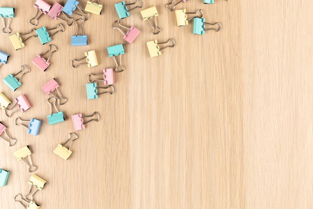 Multicolored paper clips on a wooden table