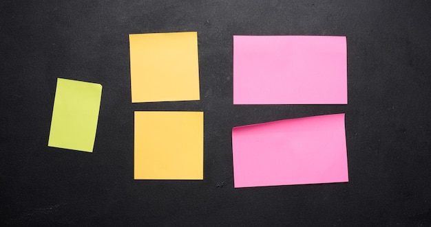 Multicolored paper stickers on a black chalkboard space for notes and labels