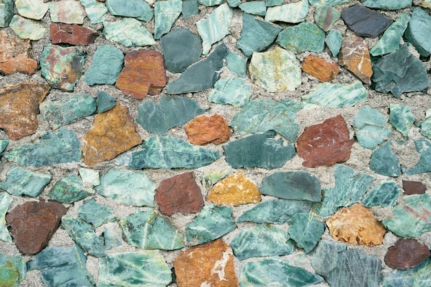 Multicolored pebbles lie on the sandy beach