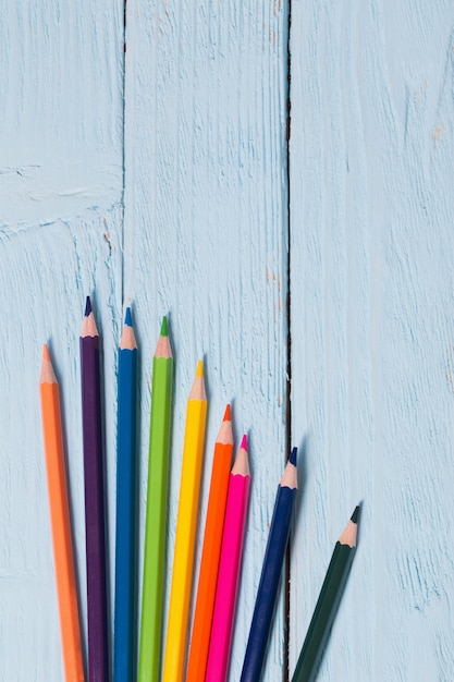 Multicolored pencils on blue wooden table