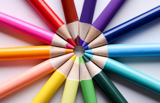 Multicolored pencils lying in shape of sun closeup