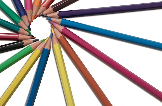 Multicolored pencils lying on a white isolated background in a circle closeup