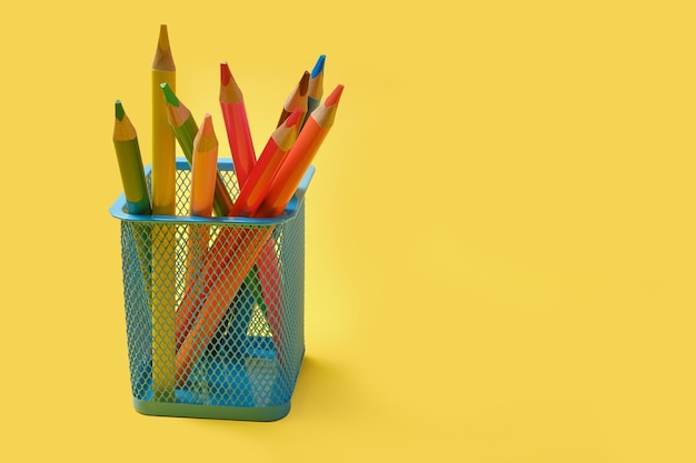 Multicolored pencils on yellow background